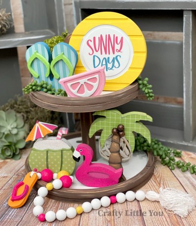 Unfinished kit measures apx. 6.5" tall on the palm tree and includes:
* 1 circle with grooves
* 1 set of flip flops
* 2 toe piece overlays
* 1 lemon with grooves
* 1 palm tree
* 1 coconut drink with shell and umbrella overlay
* 1 flamingo pool float
* Vinyl stencil