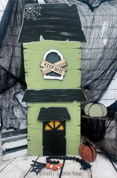 Unfinished kit measures apx. 12.5"x30" tall and includes wooden MDF: 
* Spooky House
* Window Overlay
* Roof Overlay
* Porch Roof Overlay
* Front Door
* White vinyl spiderweb
* Black vinyl "Keep Out"