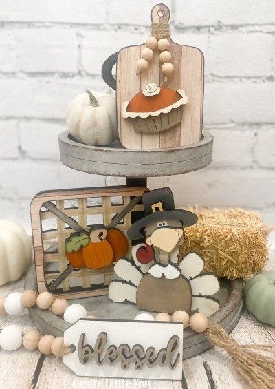 Unfinished kit measures apx. 6.25" tall on the charcuterie board and includes:
* 1 charcuterie board
* 1 pumpkin pie with whipped cream and crust overlays
* 1 basket with outside edge overlay
* 1 pumpkin with center overlay
* 1 turkey with hat brim, beak, collar, and feather overlays