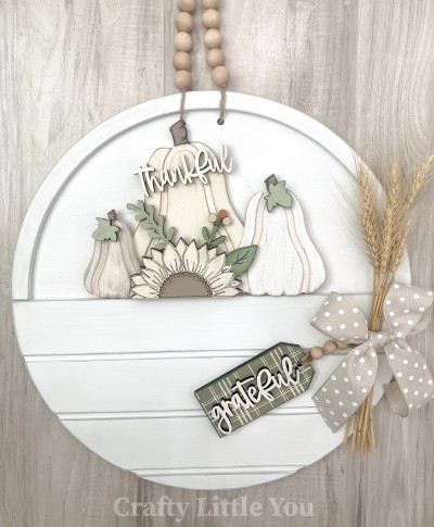 Unfinished kit measures apx. 6.75" tall and includes wooden MDF:
* 3 pumpkins with grooves
* 1 sunflower with grooves and attached leaf
* 2  vine overlays
* 2 leaf overlays
* 1 "thankful" wood word
* 2 pieces Velcro 

*Front Door Circle is not included.*