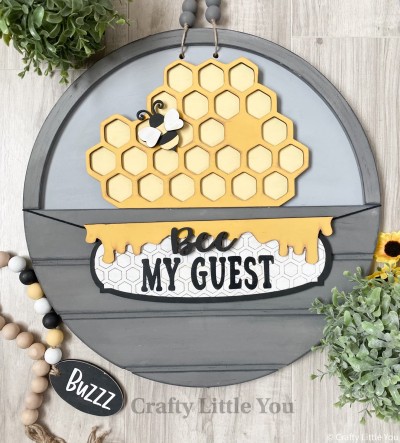 Unfinished kit measures apx. 7" tall and includes wooden MDF:
* 1 honeycomb main piece with hexagon pattern overlay
* 1 bee
* 2 bee wing overlays
* 1 hanging plaque with etched honeycomb pattern
* 1 honey drip overlay
* 1 "Bee" wood word overlay
* Black vinyl
* 2 pieces Velcro
