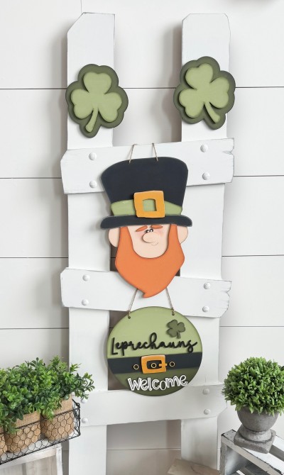 Unfinished kit measures apx.12" tall on the leprechaun, and includes wooden MDF:
*1 leprechaun main piece
*1 beard and hat brim overlay
*1 hat buckle overlay
*1 set of eyes, nose, and eyebrows overlays
*1 hanging circle
*1 set of “Leprechauns” and “Welcome” wood word overlays
*1 buckle overlay
*3 belt notch hole overlays
*1 small shamrock
*2 large shamrocks with silhouettes