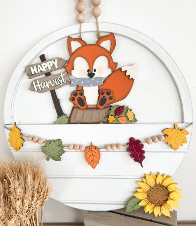 Unfinished kit is sized to fit the Front Door Circle and includes wooden MDF:
*1 fox main piece with connected stump and sign
*1 fox face and tail overlay
*1 scarf overlay
*2 fox feet overlays
*1 leaf pile with 4 individual leaf overlays
*1 set of “Happy Harvest” wood overlay words
*5 hanging leaves
*2 pieces Velcro