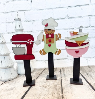 Unfinished kit measures apx.10.5"
and includes wooden MDF: *3 stands and bases *1 Mixer, peppermint *1 Gingerbread Man *1 icing bag, bakers hat, shorts *1 bowtie, heart *2 buttons
*3 icing overlays *1 set of mixing bowls with rim overlays *Black vinyl Face